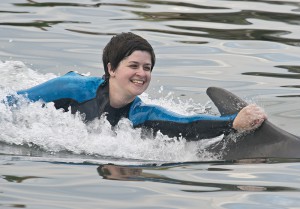 U.S. Army medic Rachael Rodgers who had her left leg amputated below the knee after being bitten by a brown recluse spider, gets a dorsal tow courtesy of Tursi the dolphin at Dolphin Research Center in Marathon.