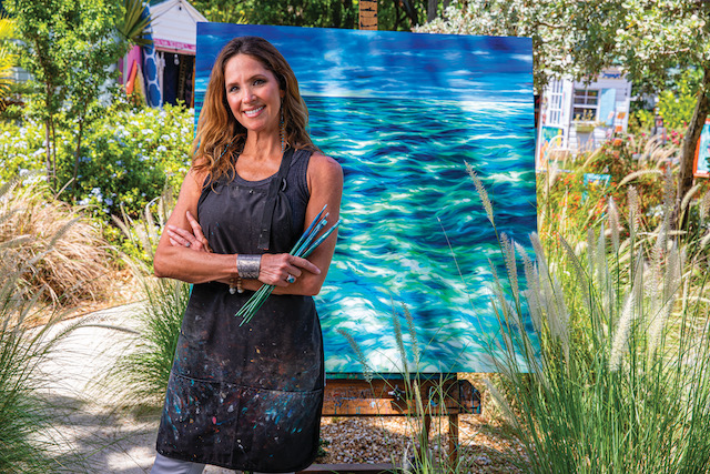 A painter standing in front of her painting