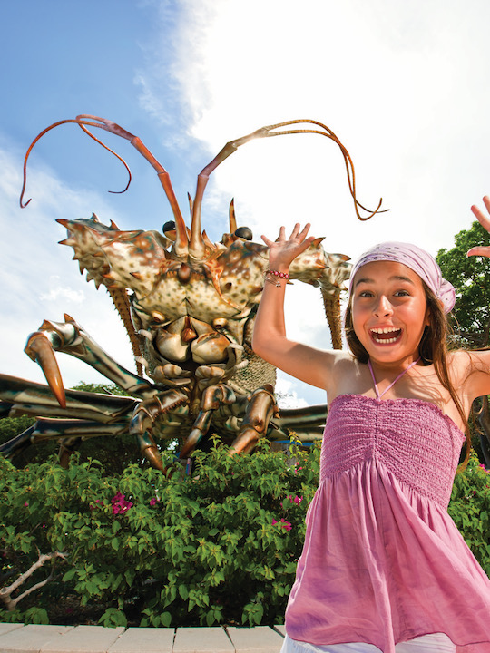 A girl posing in front of the statue of Betsy the Lobster in Islamorada