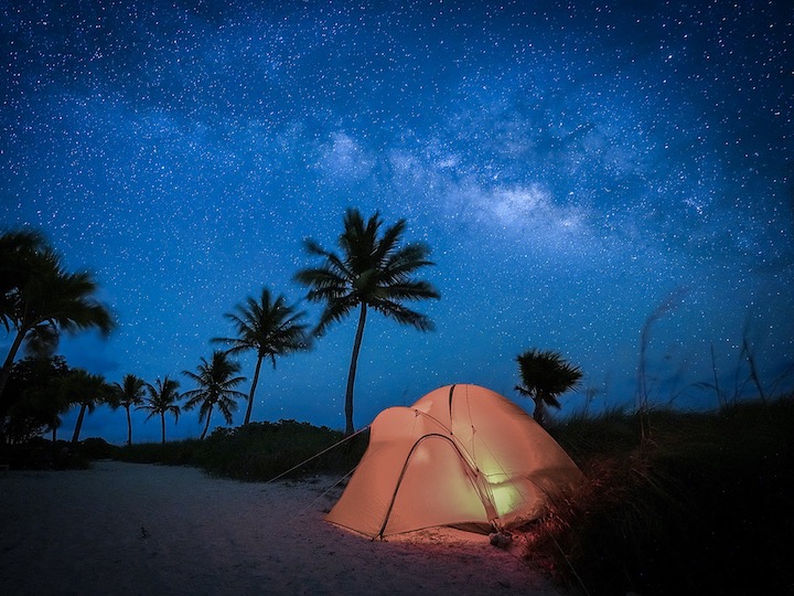 An illuminated camping tent below a starry night in the Lower Keys