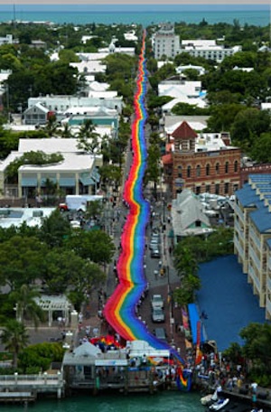 Key West's iconic 1.25-mile sea-to-sea rainbow flag blankets Duval Street with pride during its 2003 unfurling. (Photo by Andy Newman, Florida Keys News Bureau)