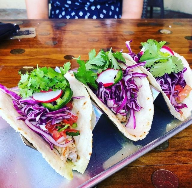 Fish tacos with red cabbage, and a little slice of radish,  jalapeño and cilantro add just the right amount of flavorful zip. 