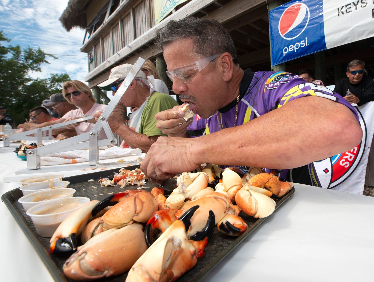 Juan Mallen consumes 25 stone crab claws in 14 minutes and 29 seconds to win the individual division of the 2021 Keys Fisheries Stone Crab Claw Eating Contest in Marathon, Fla. Image: Andy Newman/Florida Keys News Bureau