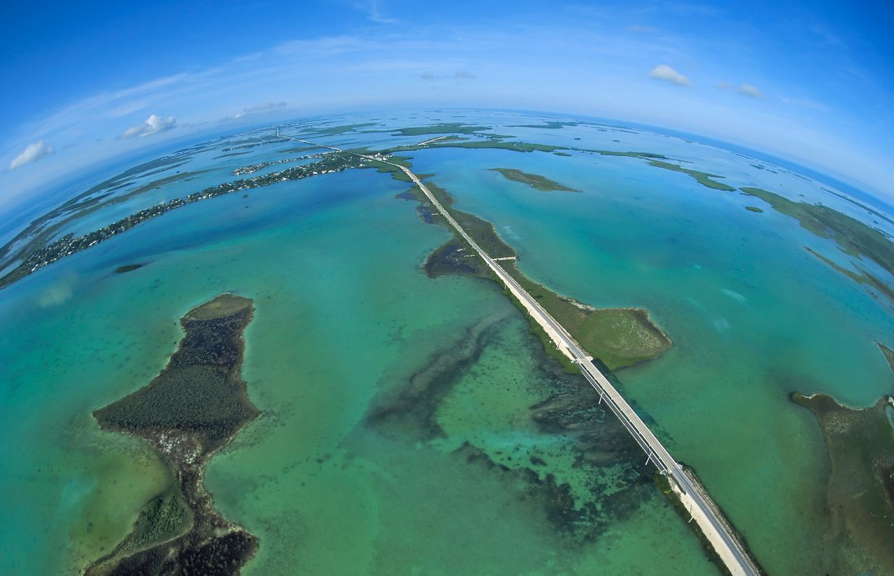 A full-frame fisheye lens helps to provide a unique view of the Florida Keys' Overseas Highway as it bisects the Atlantic Ocean, left, and the Gulf of Mexico, right, near Big Pine Key. Photo: Andy Newman.
