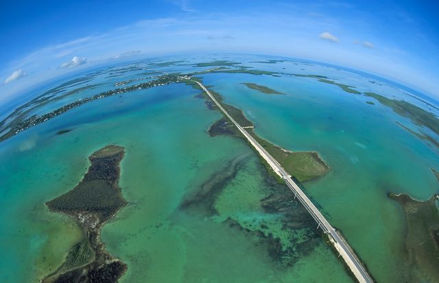 A full-frame fisheye lens helps to provide a unique view of the Florida Keys' Overseas Highway as it bisects the Atlantic Ocean, left, and the Gulf of Mexico, right, near Big Pine Key. Photo: Andy Newman