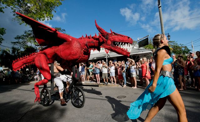 Samantha Usina, right, leads David Hutchinson, left, pedaling his Queen of Dragons artwork during a previous Papio Kinetic Sculpture & Art Bike Parade. Photo: Rob O'Neal