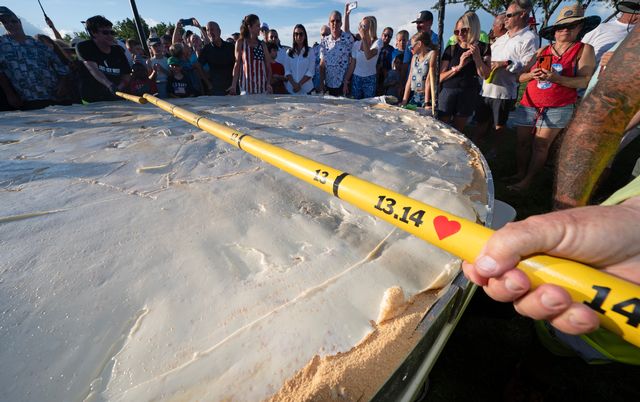A measuring stick confirms the diameter of a gargantuan Key lime pie created for a 200th Florida Keys birthday celebration Monday.