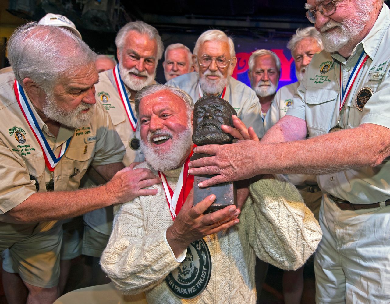 Jon Auvil, center, receives an Ernest Hemingway bust and congratulations after he won the 2022 Hemingway Look-Alike Contest at Sloppy Joe’s Bar in Key West. Photo: Andy Newman