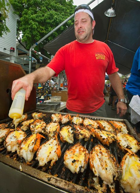 A chef grills fresh Keys lobster tails soaked in butter during the Key West Lobsterfest Street Fair. 