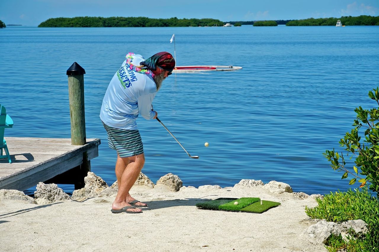 Golfers loft biodegradable fish-food golf balls at floating holes during the annual Conch Scramble charity golf tournament. Photos courtesy of Conch Scramble.