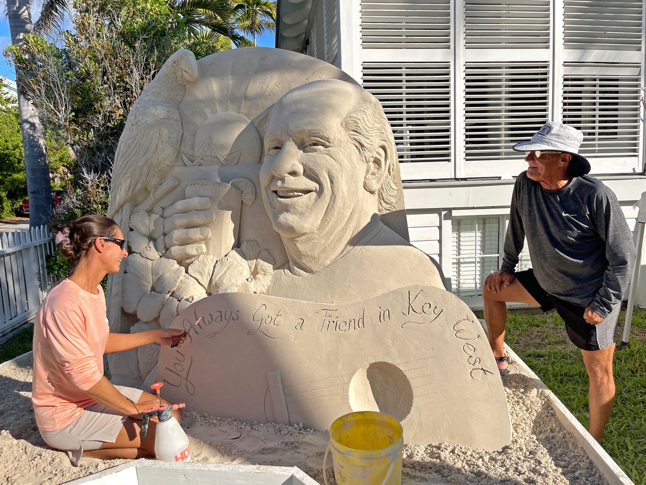 Sand sculptor Marianne van den Broek finishes a sculpture in Key West memorializing singer/songwriter Jimmy Buffett, while musician C.W. Colt looks on. Photo: Rob O'Neal