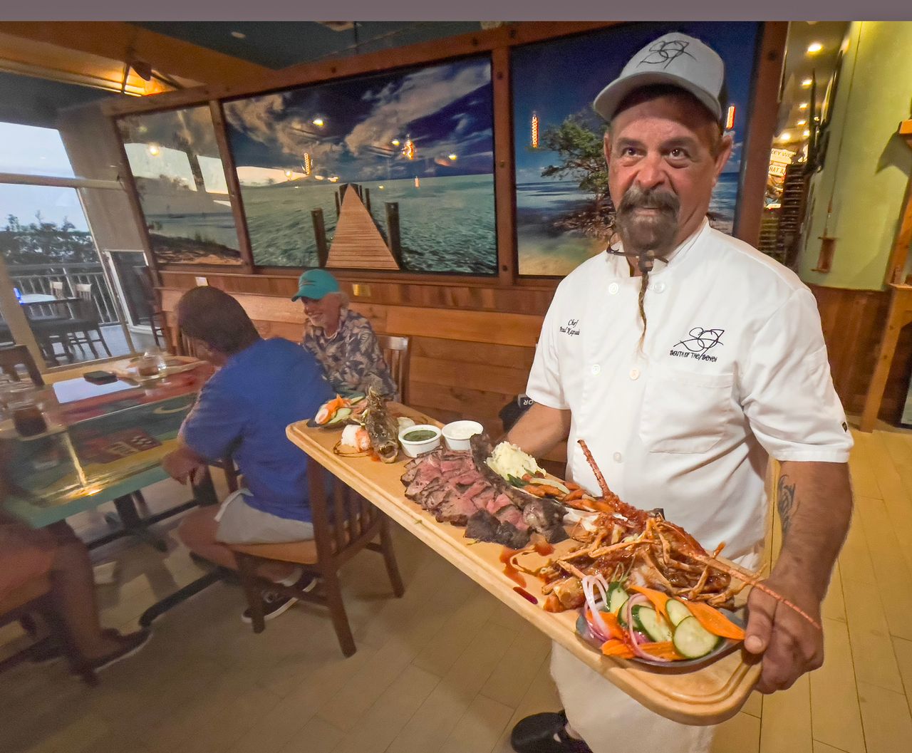 Chef Paul Kapsalis presents some of his chef's special dishes including whole fried fish with Thai chili sauce, bone-in tomahawk ribeye steak and soft shell Florida lobster. Photo: Andy Newman