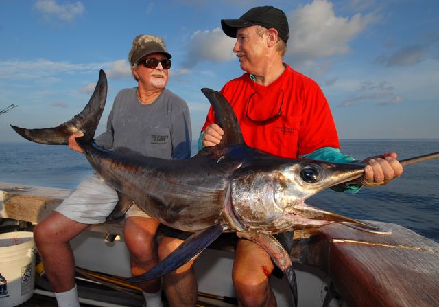 Richard Stanczyk, left, owner of Bud N' Mary's Marina, holds a swordfish caught during daylight hours by Vic Gaspeny while fishing off Islamorada. Stanczyk and Gaspeny pioneered daytime swordfishing off the Florida Keys. Photo: Andy Newman