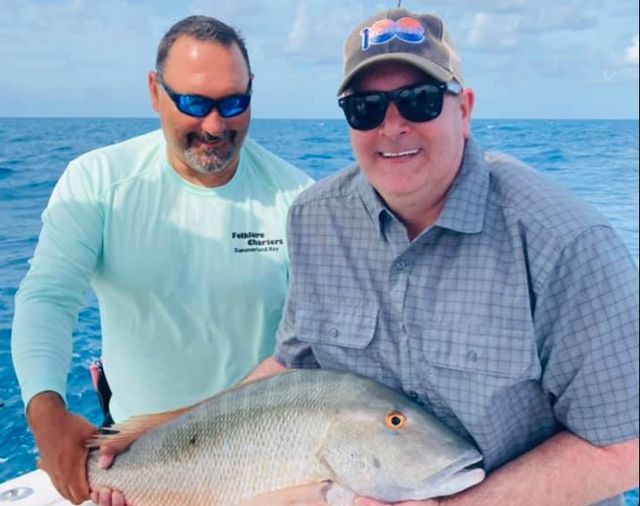 Captain Betz and a Folklure  Fishing Charters customer with a catch of mutton snapper. 