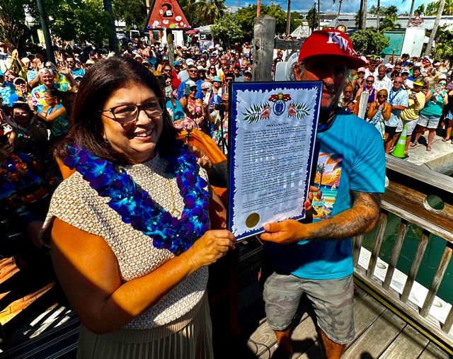 Key West Mayor DeeDee Henriquez holds the City's proclamation along with Paul Menta, a founder of the Just a Few Friends Buffett-themed event held over the 2024 Labor Day Weekend.