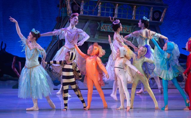 Young children costumed as colorful fish perform in a scene set on the Keys' coral reef. 