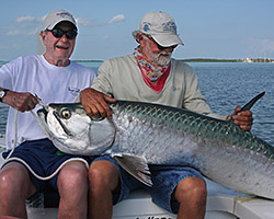 Former President Bush, left, shows off the big tarpon that he caught with guide George Wood, just before the fish was released. Photo by Andy Mill