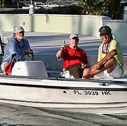 Former President Bush, center, gestures as he and Florida Keys fishing guide George Woods, left, and former Olympic skier Andy Mill, right, leave the dock for their first day of fishing April 19. Photo by Bob Care/Florida Keys News Bureau