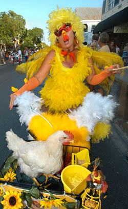 Sonja Jones of Key West, rides her bicycle down Duval Street with her pet chicken Henry during the "Poultry in Motion" Parade.