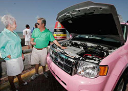 Glenn Stevenson of Five Sixes Taxi (right) shows Florida Keys commissioner Dixie Spehar the inner workings of the eco hybrid taxi. 