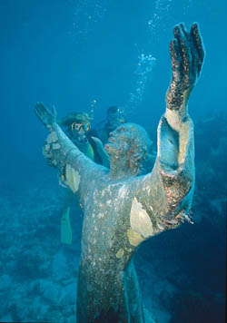 Divers survey the Christ of the Deep statue in the Key Largo National Marine Sanctuary. This nine-foot-tall, 4,000 pound replica of the Christ of the Abysses located in the waters off the coast of Italy is submerged in 25 feet of water. Photo by Stephen Frink/Florida Keys News Bureau.
