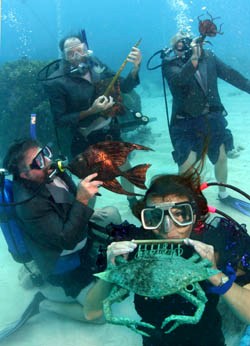 Divers pretend to play replicas of musical instruments including a French angelfish horn, Sa manta-lin, a harmoni-crab and a trombonefish at the annual Underwater Music Festival 